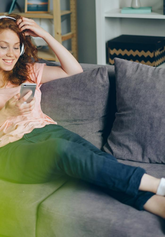 a person with a cell phone sitting on a couch