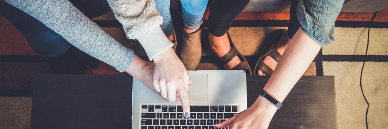 people pointing at a laptop